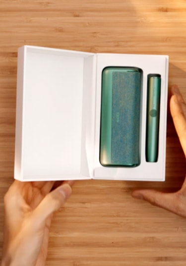 A Jade Green IQOS ILUMA PRIME holder and Pocket Charger in a box.