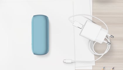 Turquoise IQOS ORIGINALS DUO pocket charger next to cable charger.